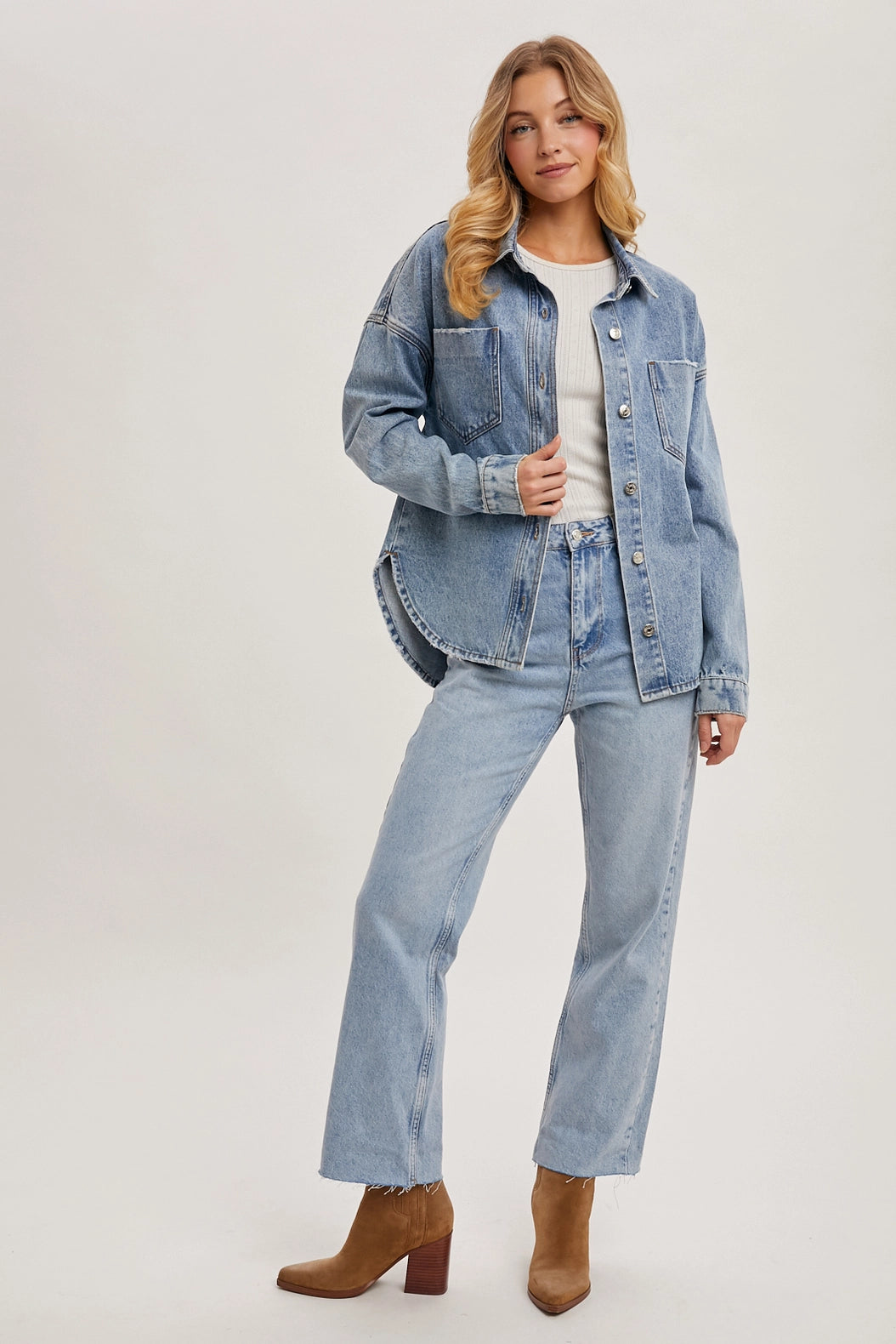 Woman wearing a denim jacket and jeans on a white background