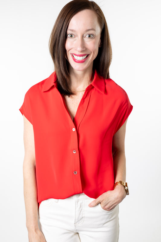 Woman wearing a red blouse and white pants on a white background