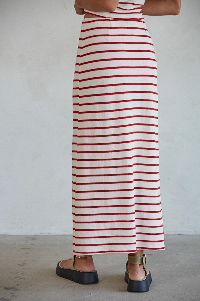 Person wearing a red and white striped dress against a plain background