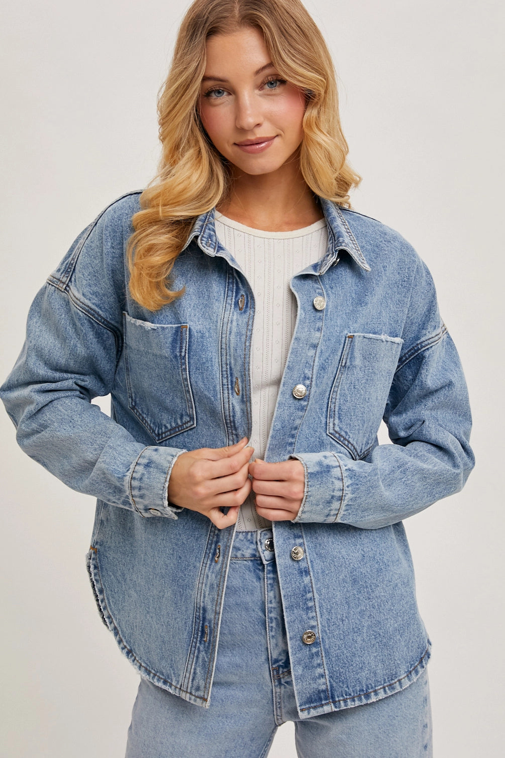 Woman wearing a denim jacket on a plain background