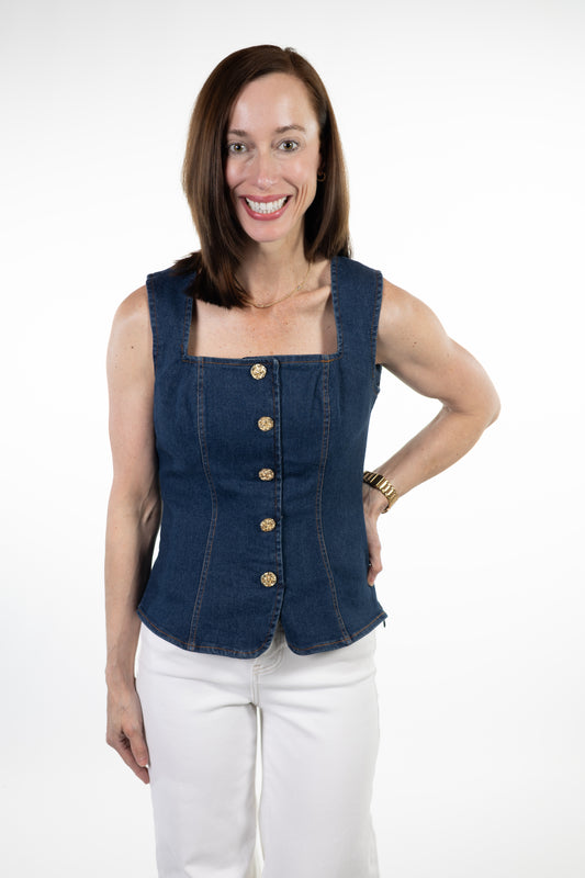Woman wearing a blue denim vest over a white top on a white background