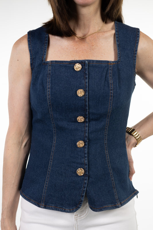 Woman wearing a blue denim vest with gold buttons on a white background