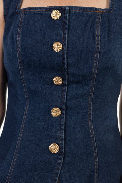 Close-up of a navy blue denim dress with gold buttons.