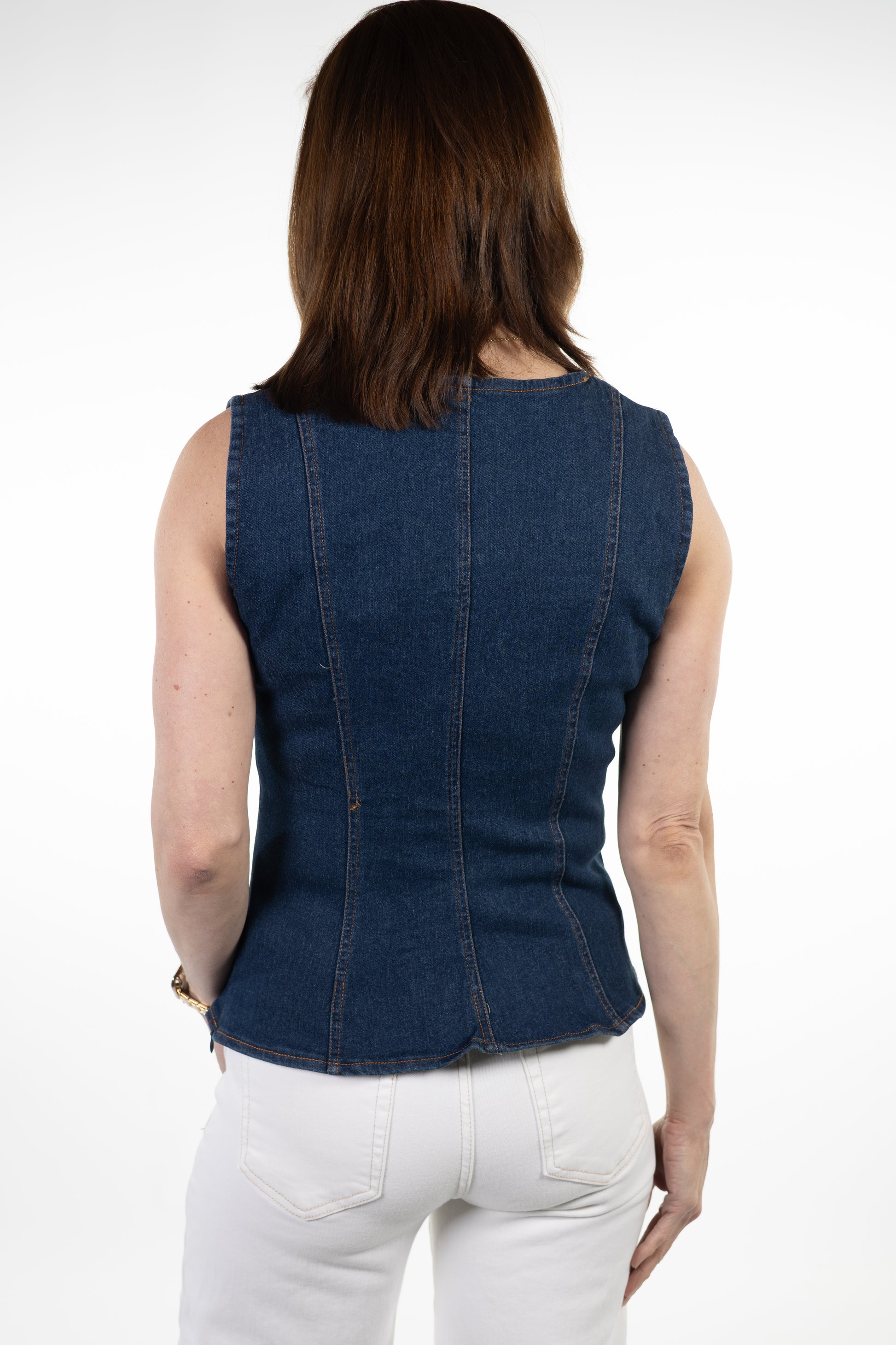 Woman wearing a blue denim sleeveless top on a white background