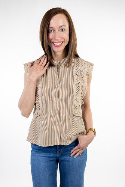 Woman wearing a beige striped shirt with lace details on a white background
