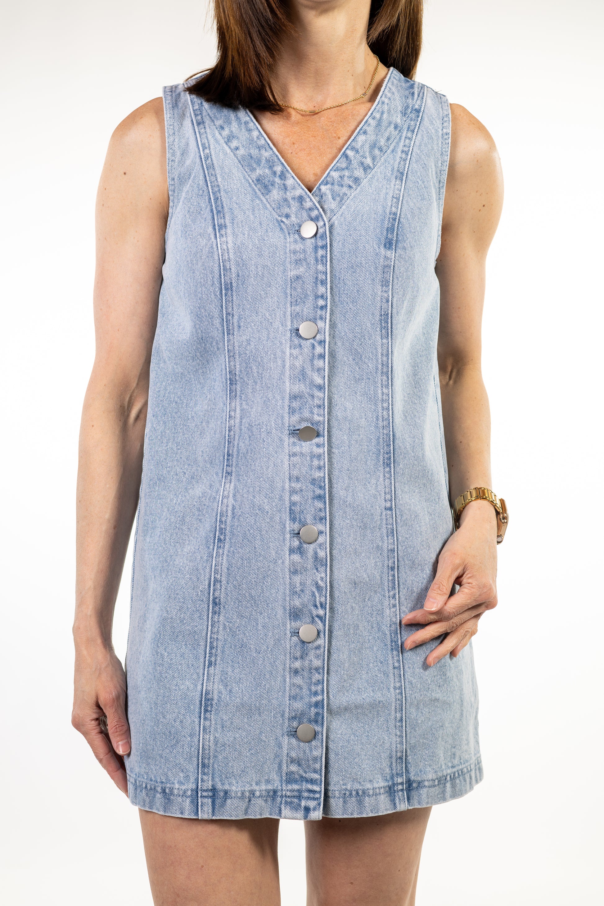 Woman wearing a sleeveless denim dress on a white background