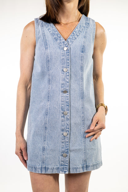Woman wearing a sleeveless denim dress on a white background