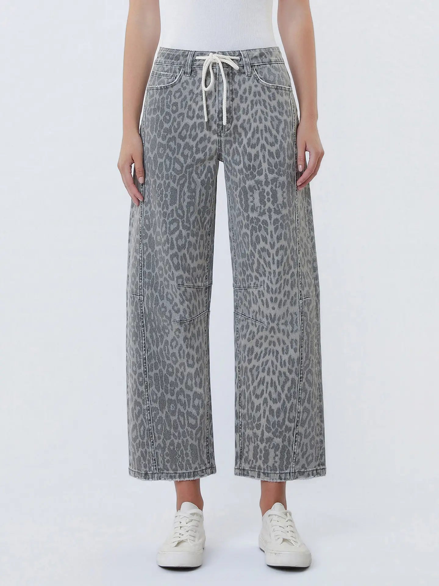 Person wearing gray leopard print pants on a white background