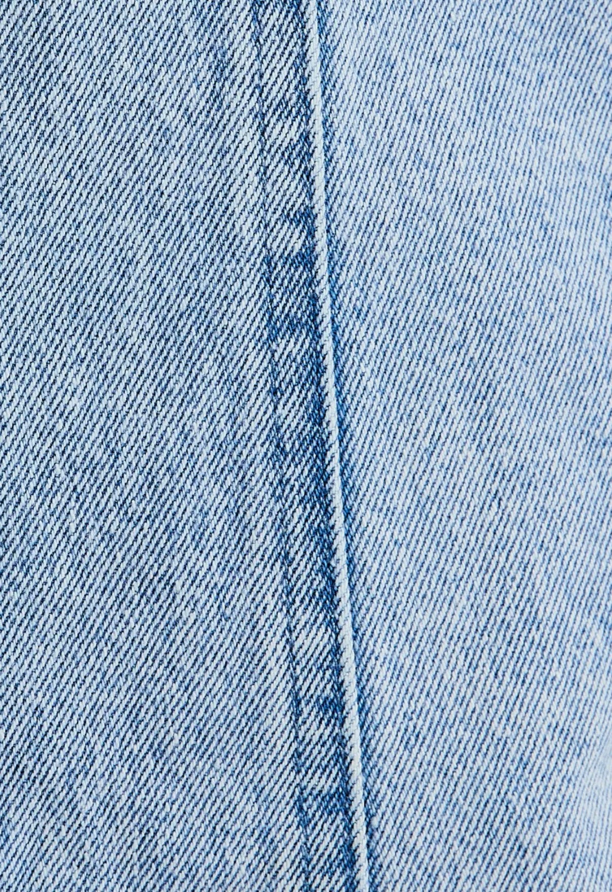 Close-up of blue denim fabric with a visible seam.