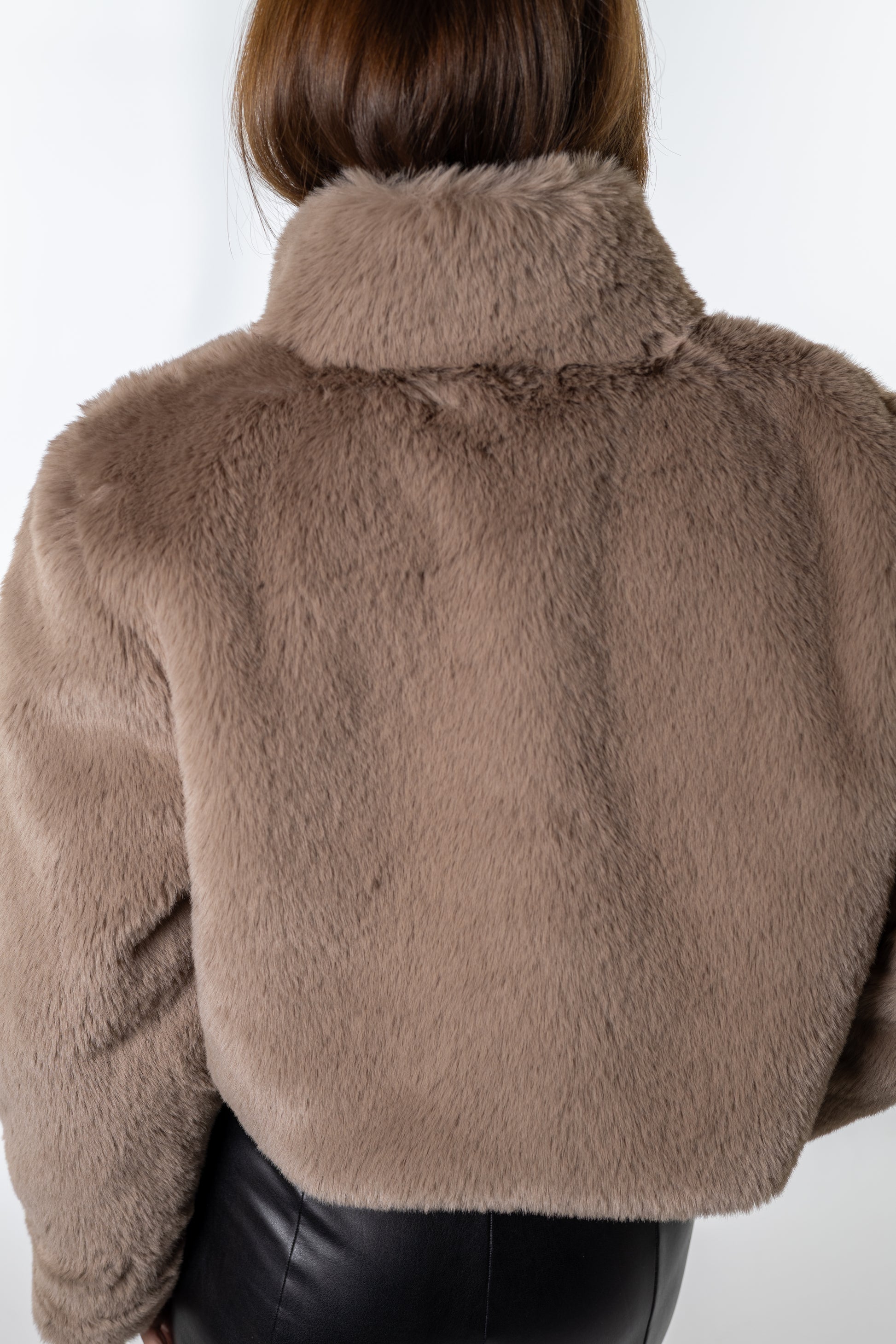 Taupe faux-fur jacket from Salt & Lavender Clothing styled with faux-leather leggings — warm, trendy outerwear piece for festive events and casual wear.