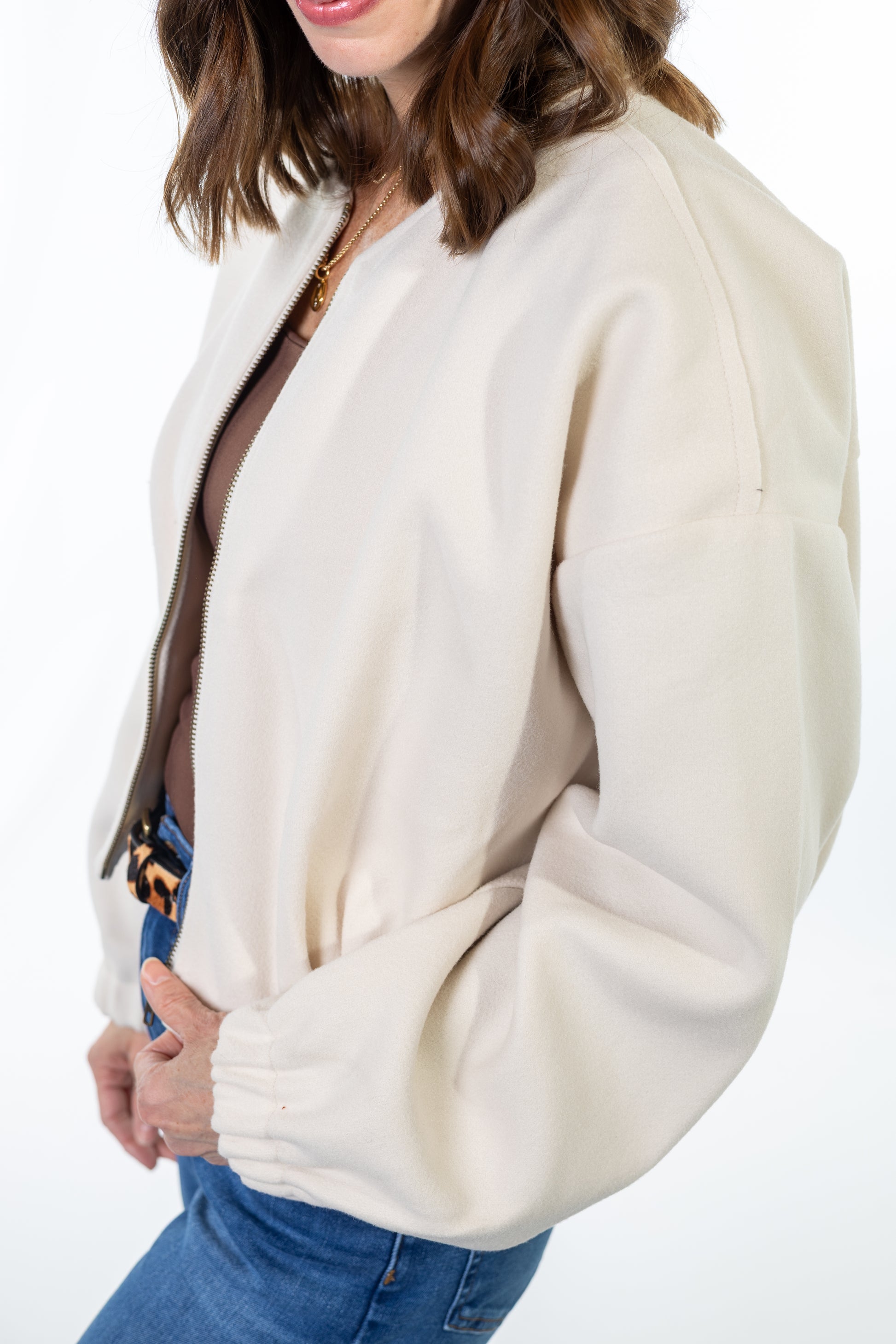 Woman wearing a cream-colored jacket on a white background