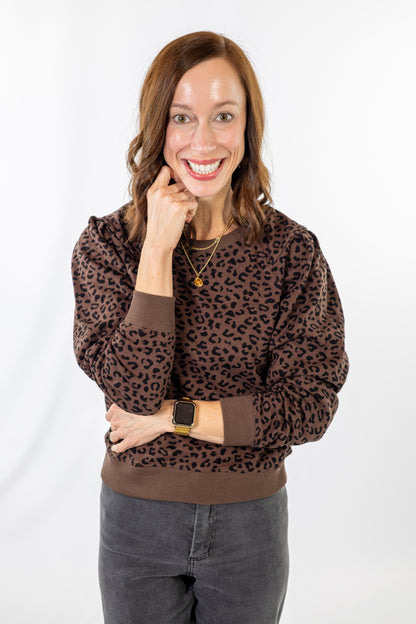 Woman wearing a brown leopard print sweater on a white background