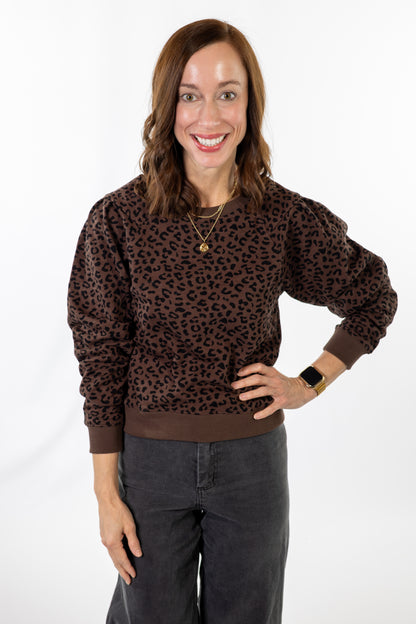 Woman wearing a brown leopard print sweater on a white background