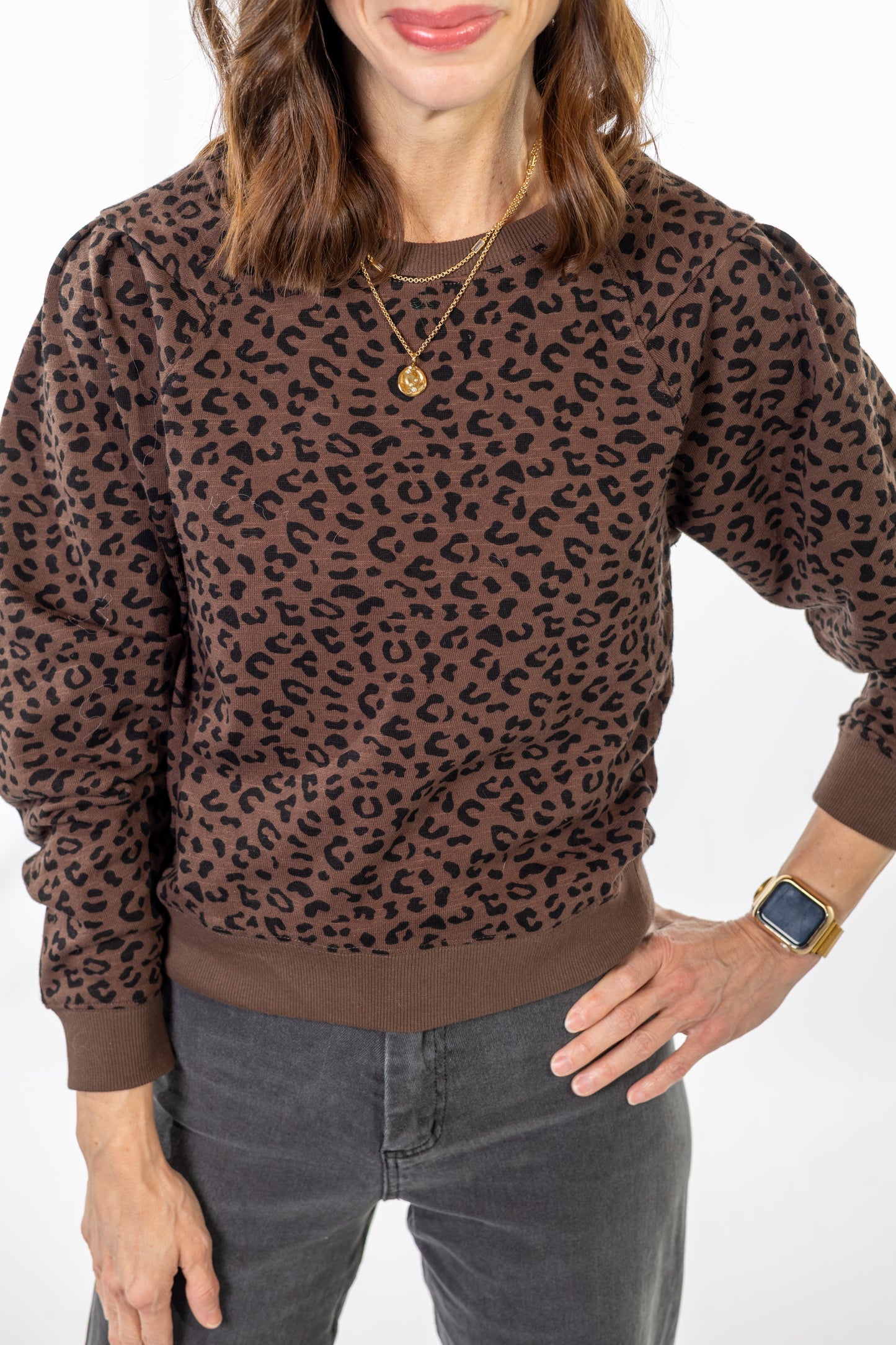 Person wearing a brown leopard print sweater on a white background