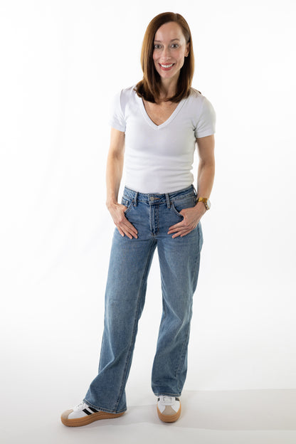 Woman wearing a white t-shirt and blue jeans on a white background