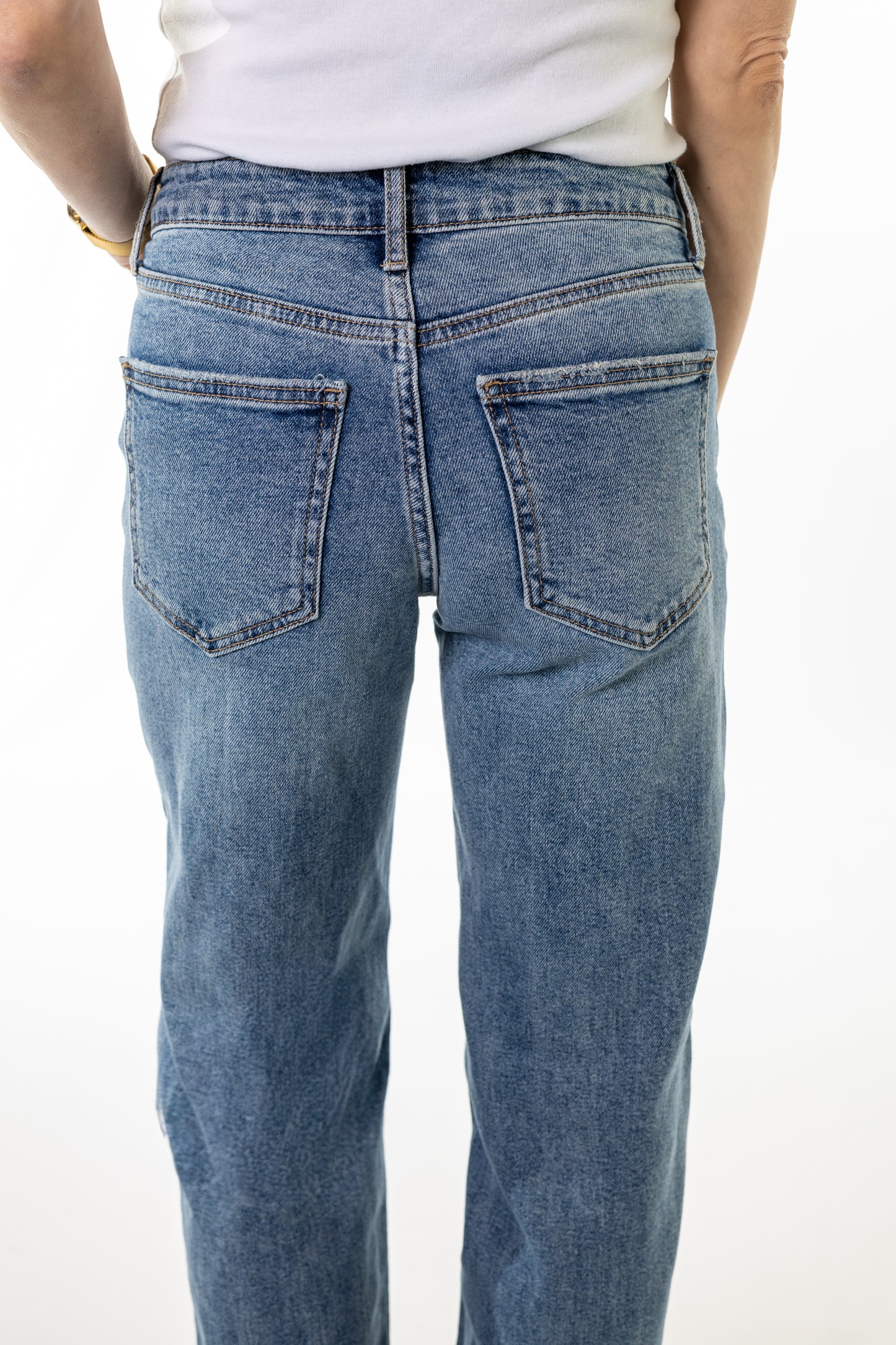 Blue jeans worn by a person on a white background