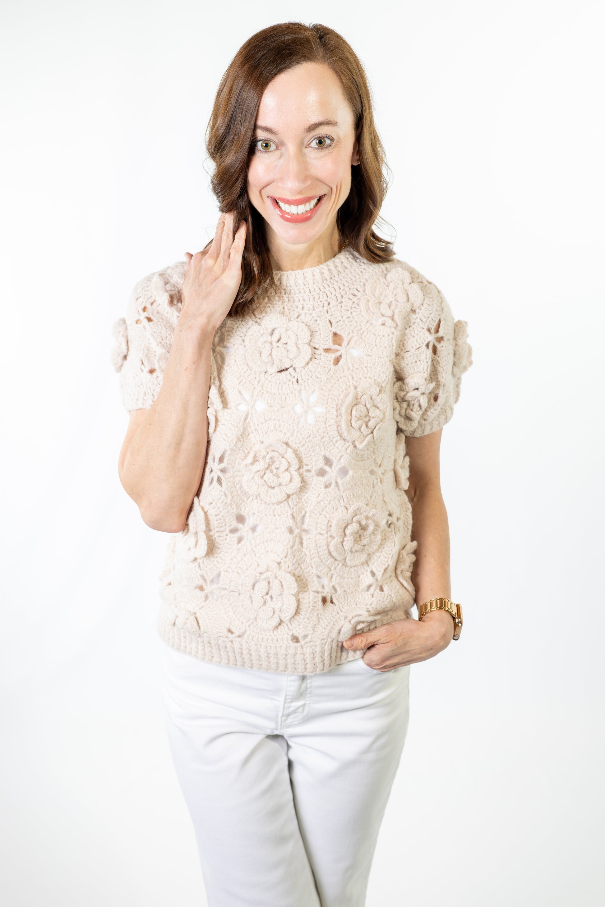 Woman wearing a beige floral-patterned sweater on a white background