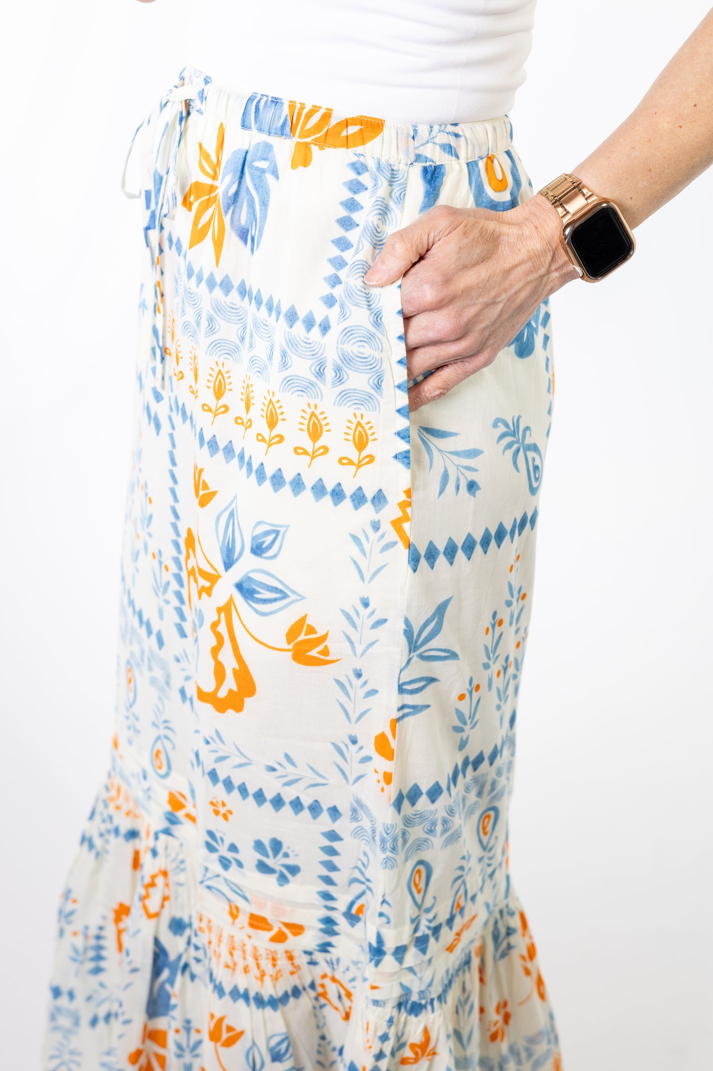 Person wearing a colorful patterned skirt with a white background
