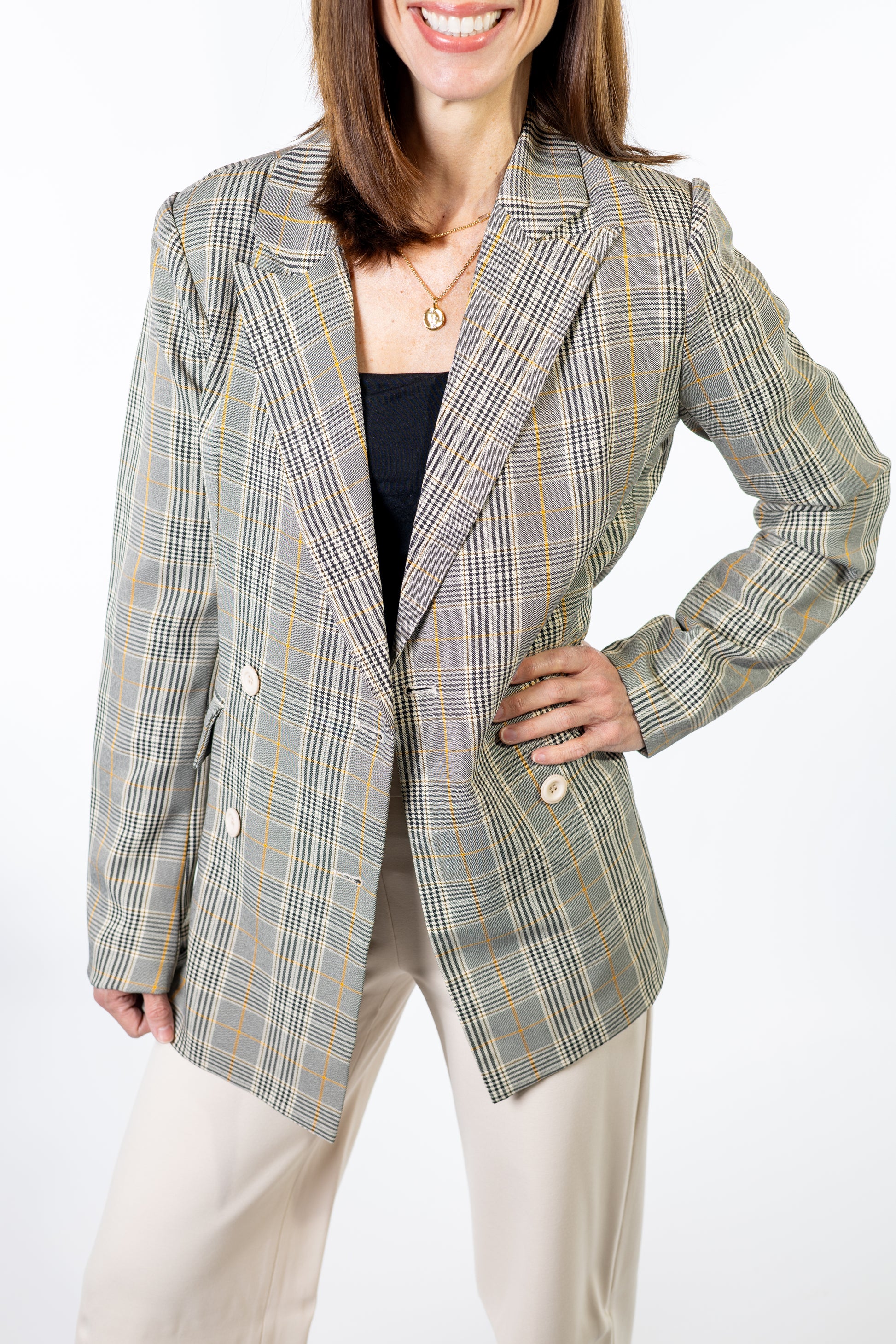 Woman wearing a plaid spring blazer on a white background