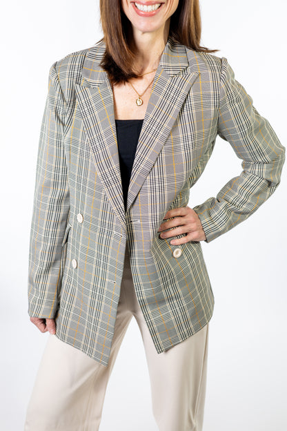 Woman wearing a plaid spring blazer on a white background