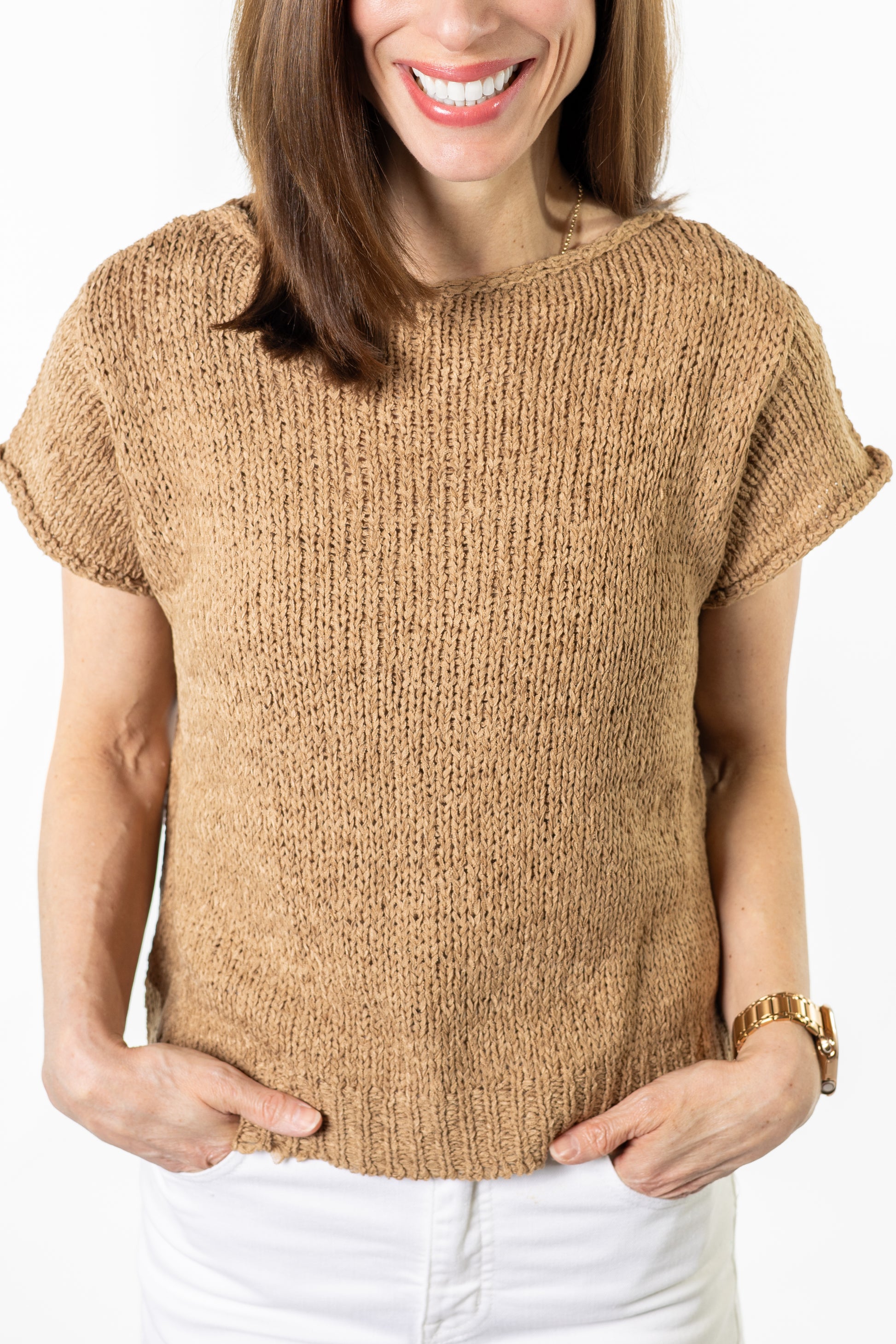 Woman wearing a beige knitted sleeveless sweater on a white background