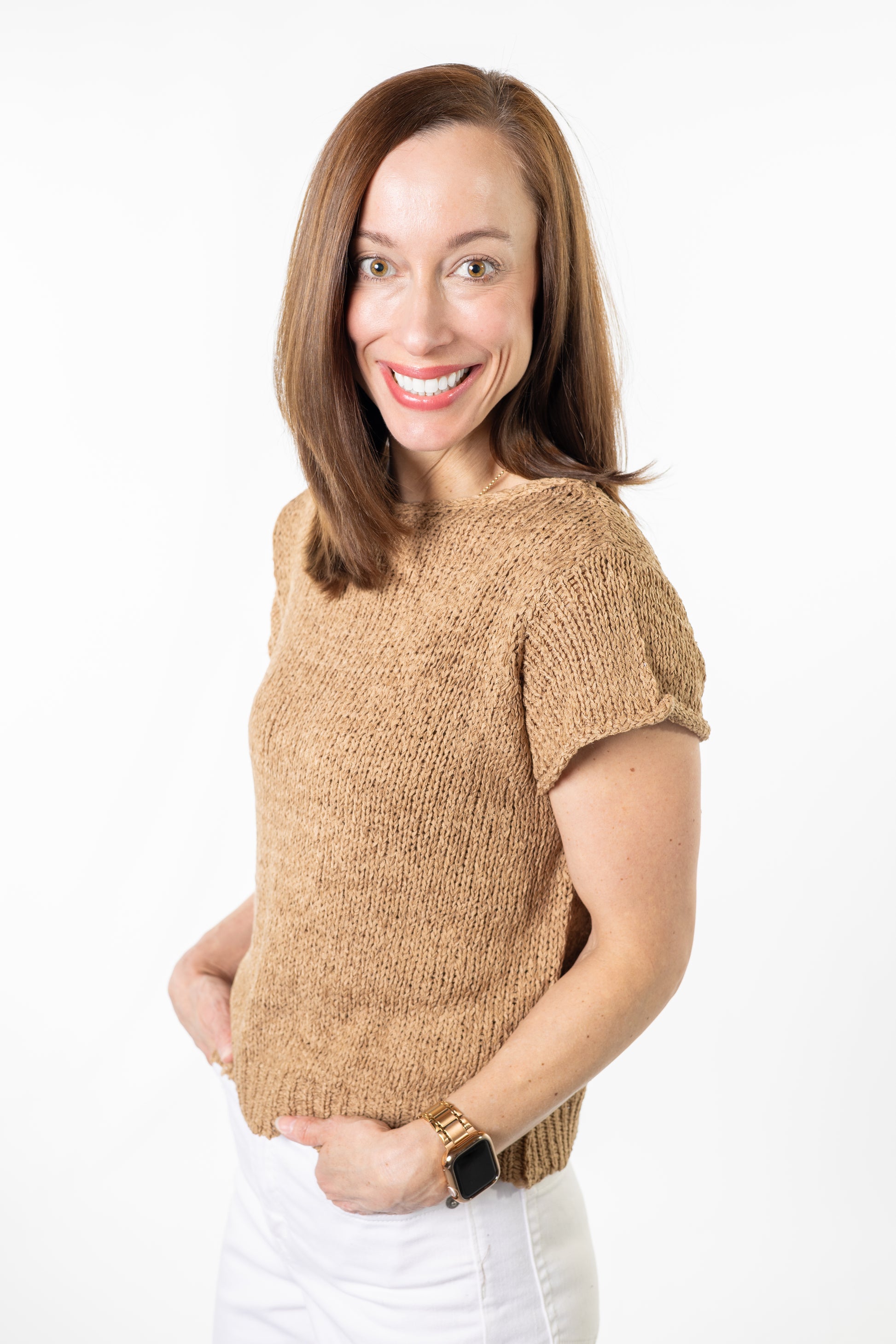Woman wearing a beige knitted sweater on a white background