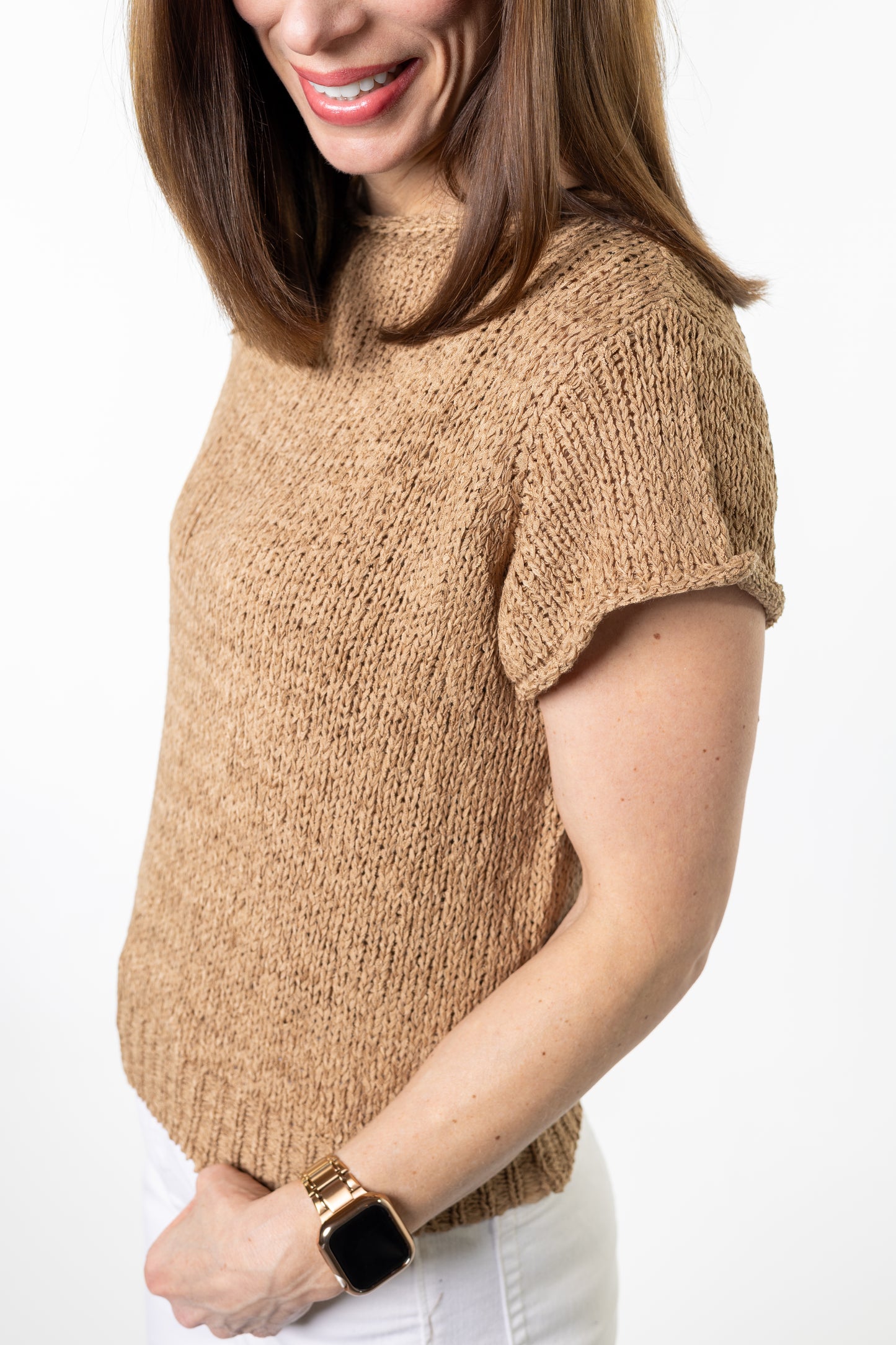 Woman wearing a beige knit sweater on a white background