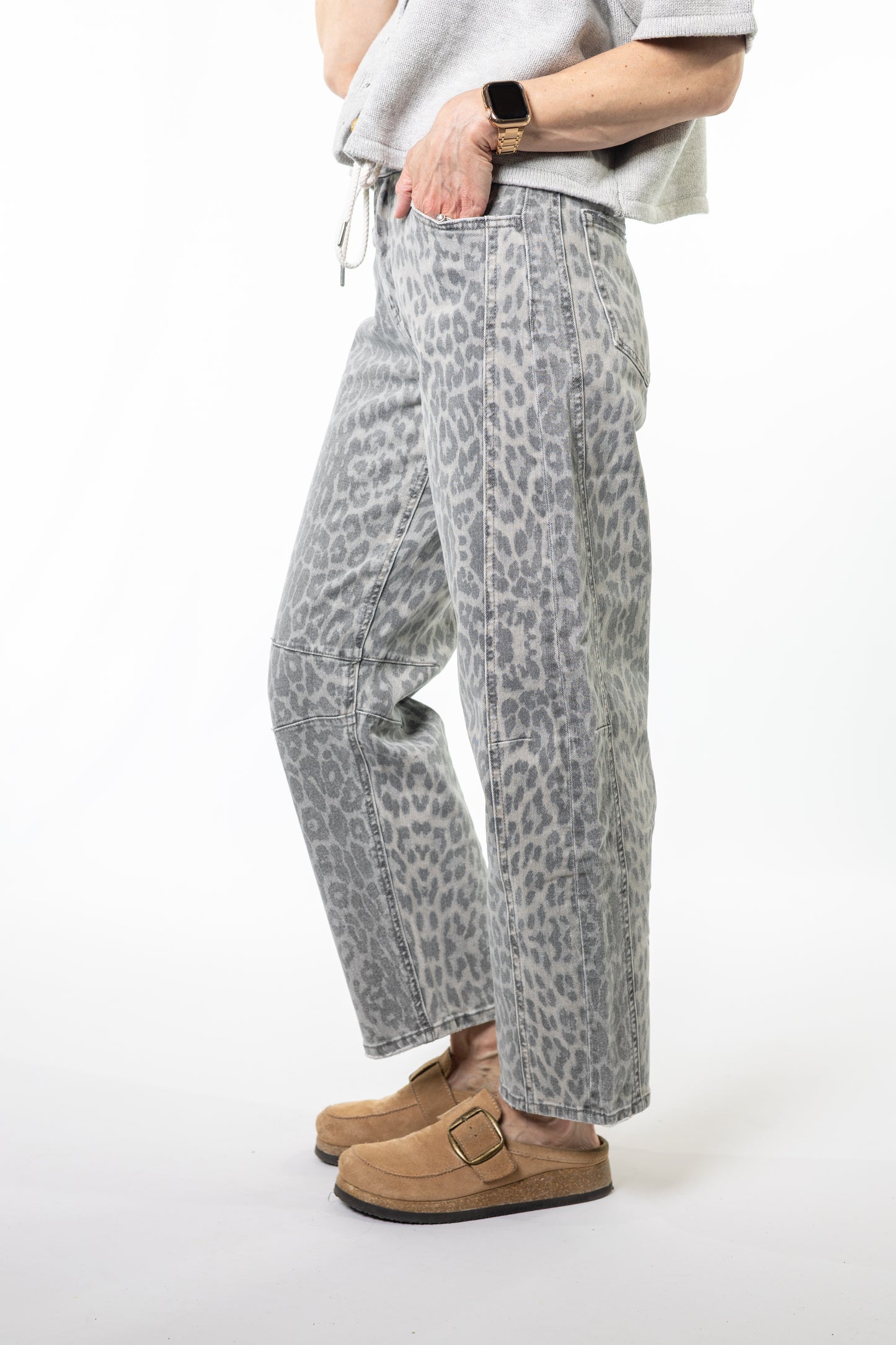 Person wearing gray leopard print pants on a white background
