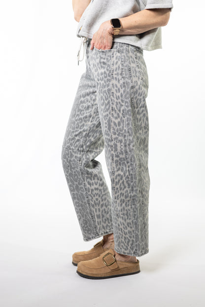 Person wearing gray leopard print pants on a white background