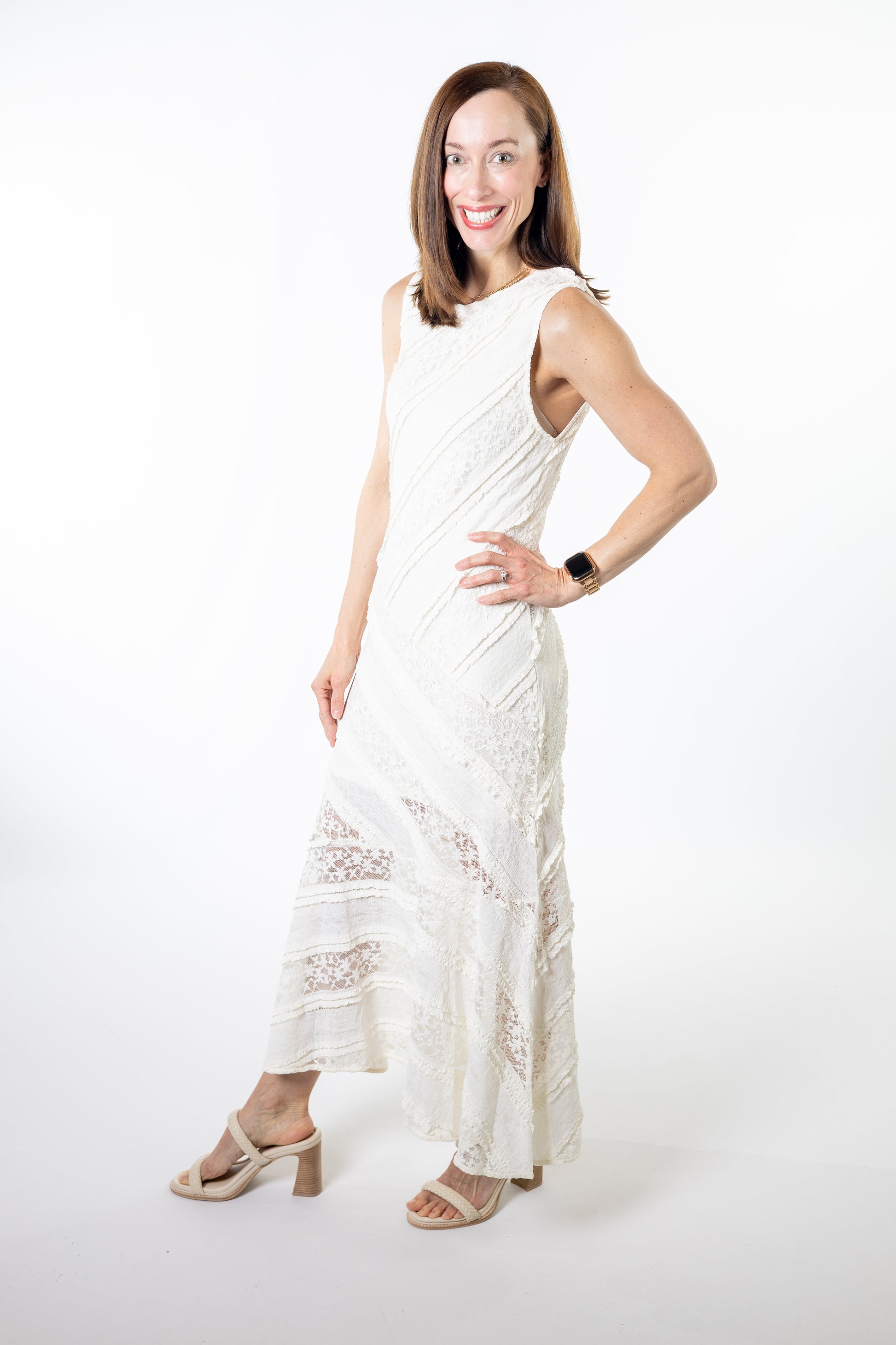 Woman wearing a white ivory sleeveless dress with lace details on a white background