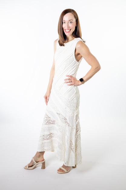 Woman wearing a white ivory sleeveless dress with lace details on a white background