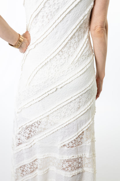 Close-up of a white ivory lace dress with a person wearing it on a white background
