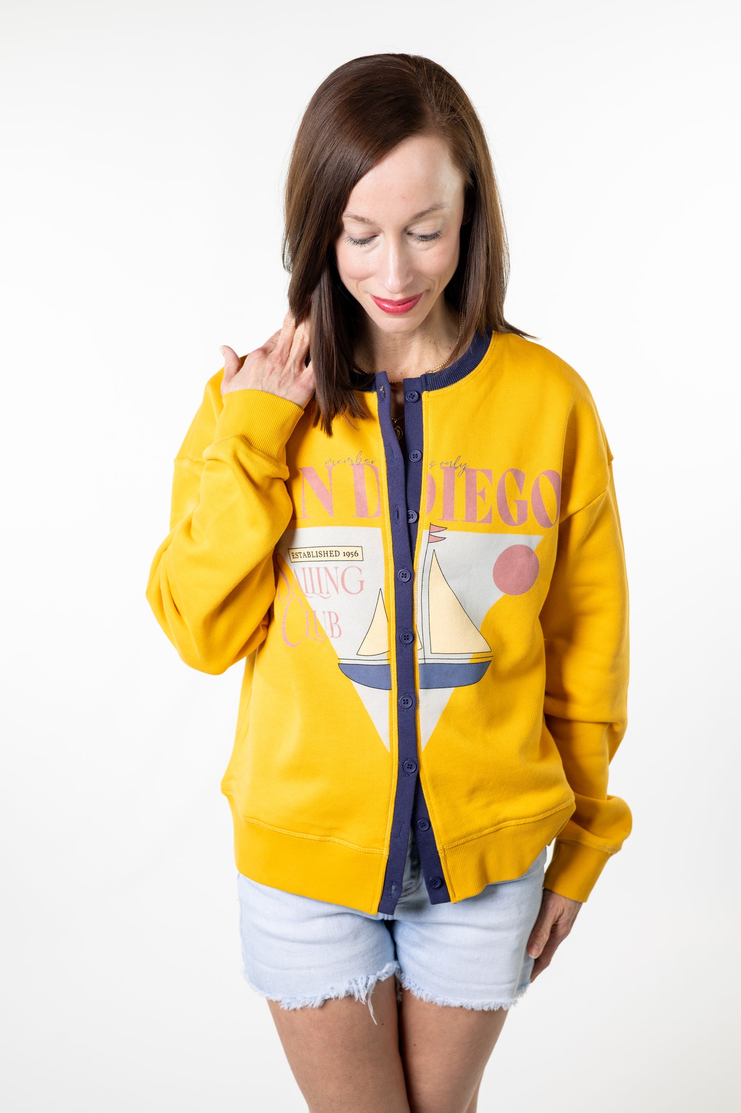Woman wearing a yellow hoodie with a graphic design on a white background