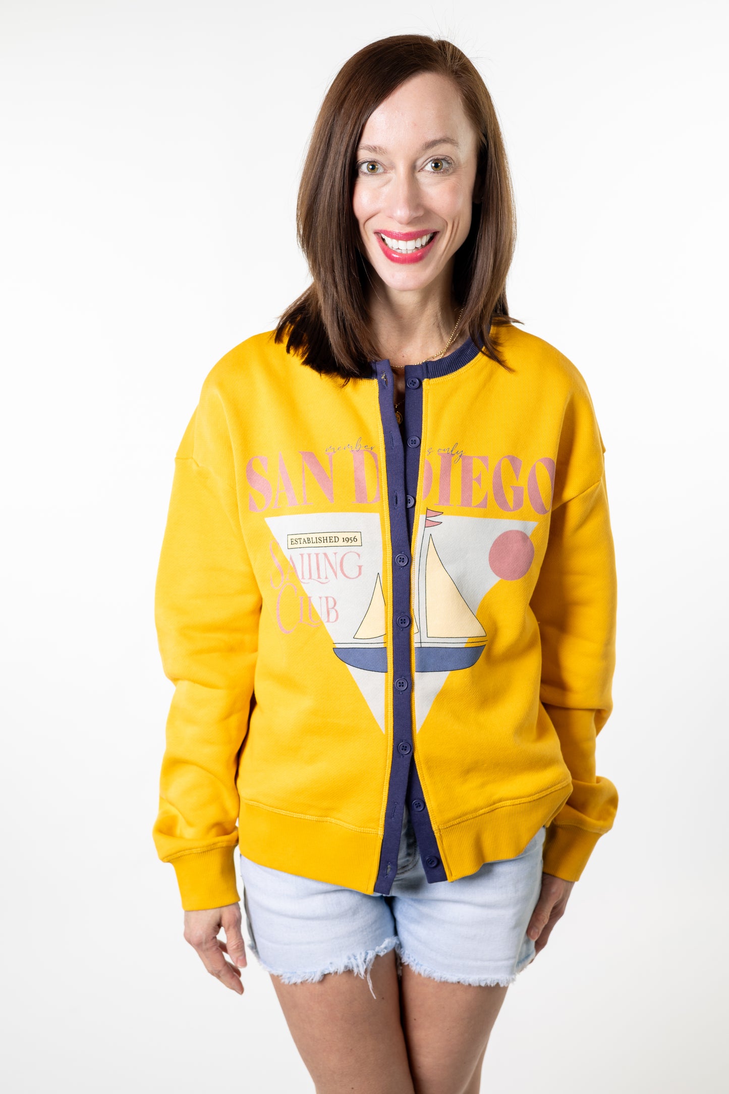 Woman wearing a yellow 'San Diego' sweatshirt with a graphic design on a white background