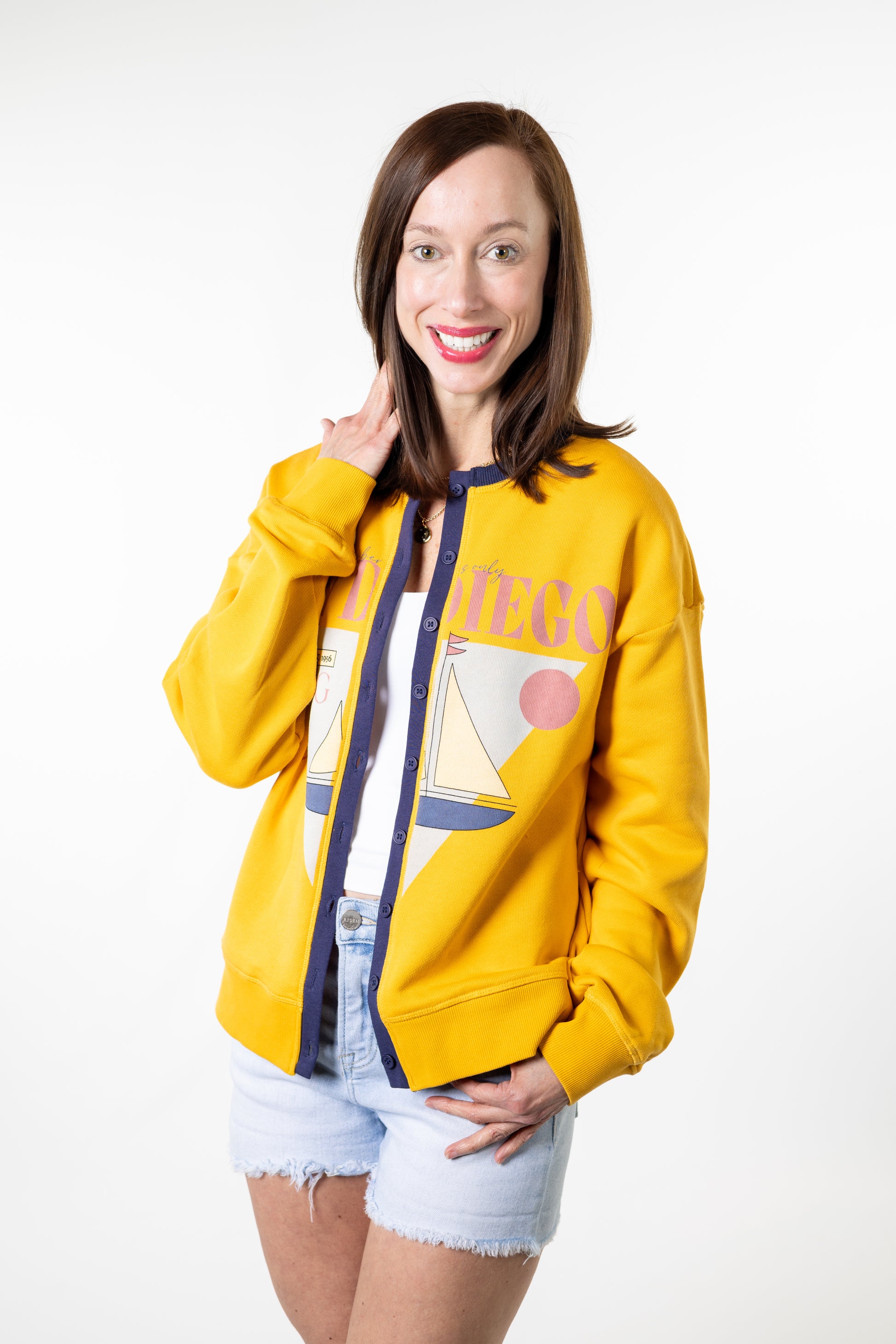 Woman wearing a yellow jacket with a visible brand logo on a white background