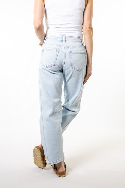 Light blue high rise barrel jeans worn by a person on a white background