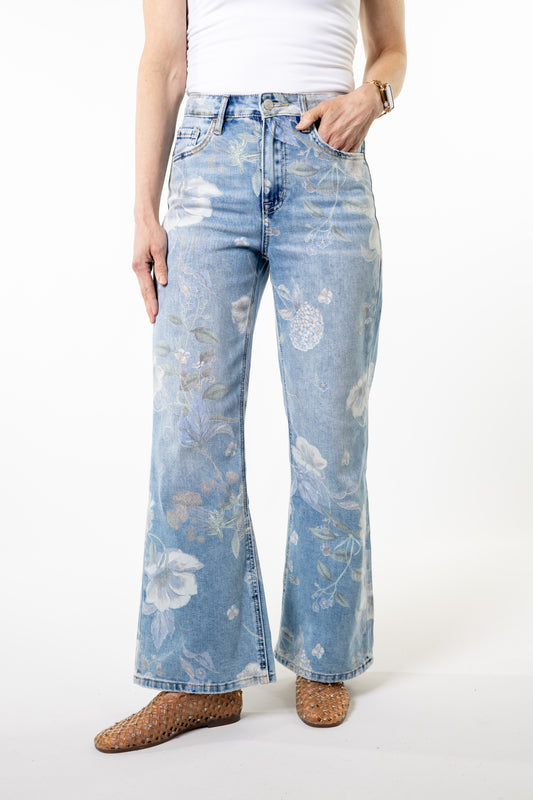 Light blue floral-patterned jeans worn by a person on a white background