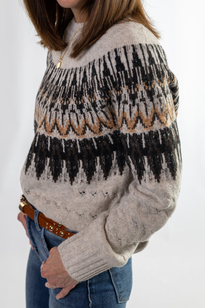 Person wearing a fair isle patterned sweater with a white background