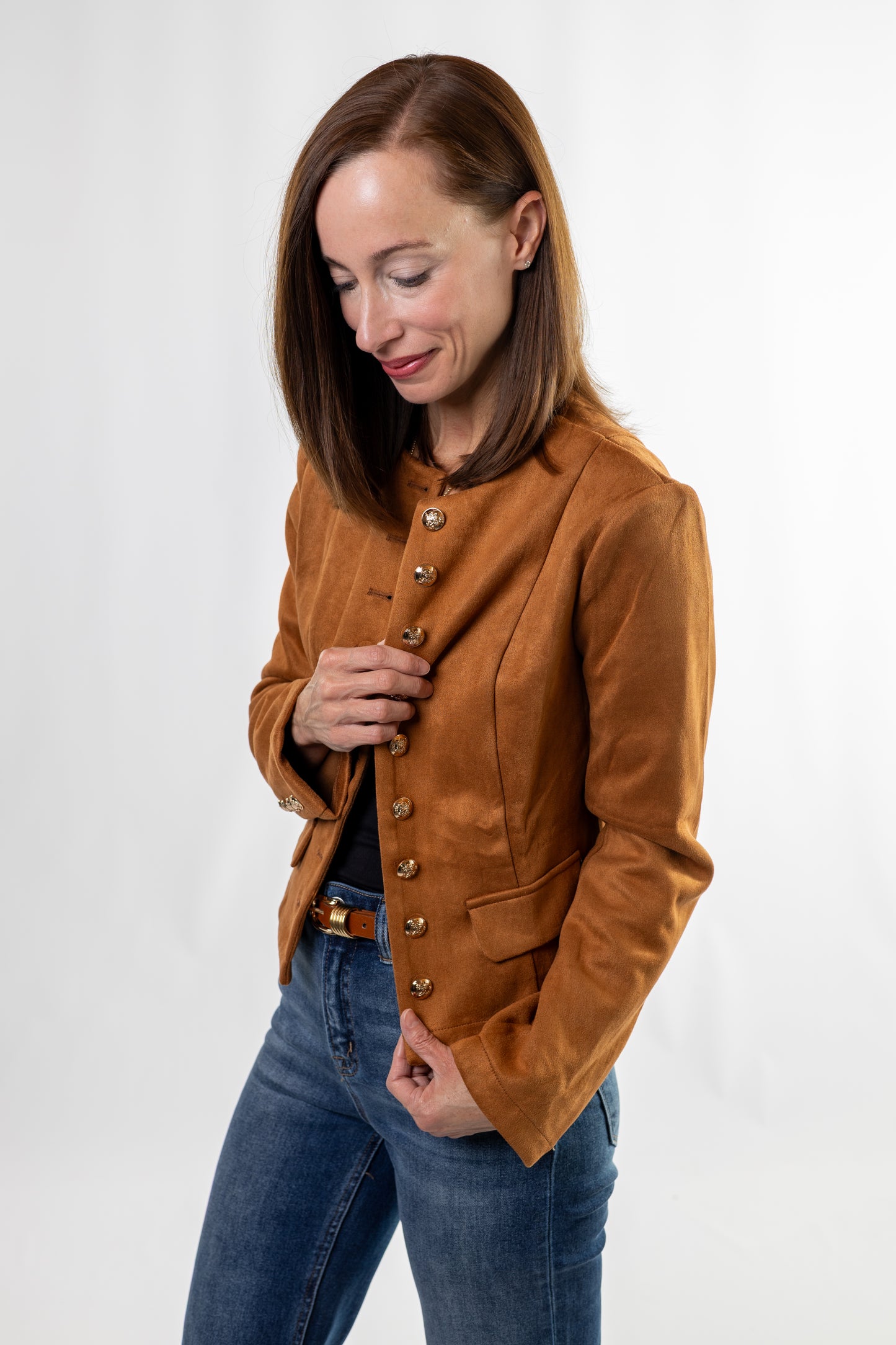 Woman wearing a brown jacket and blue jeans on a white background